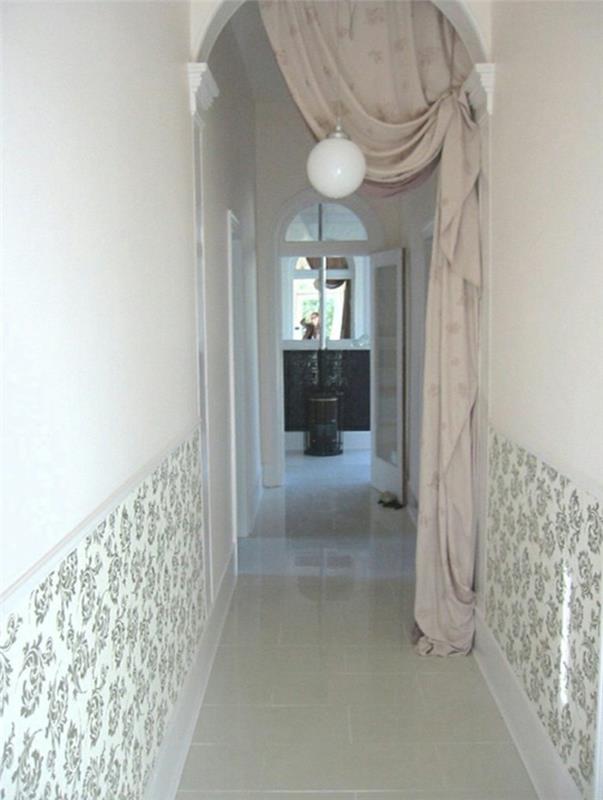 vhod na lok z bledo bež zaveso, ki vodi v ozek hodnik, z belimi stenami, delno prekritimi s črno -belimi cvetličnimi ozadji, ideje za majhne hodnike
