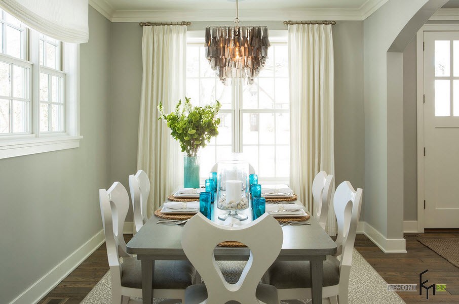 Accenti nell'interno luminoso della sala da pranzo con tende bianche