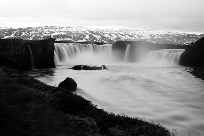 črno -bela podoba veličastnega slapa in njegovih žarečih belih voda, enobarvna krajinska fotografija
