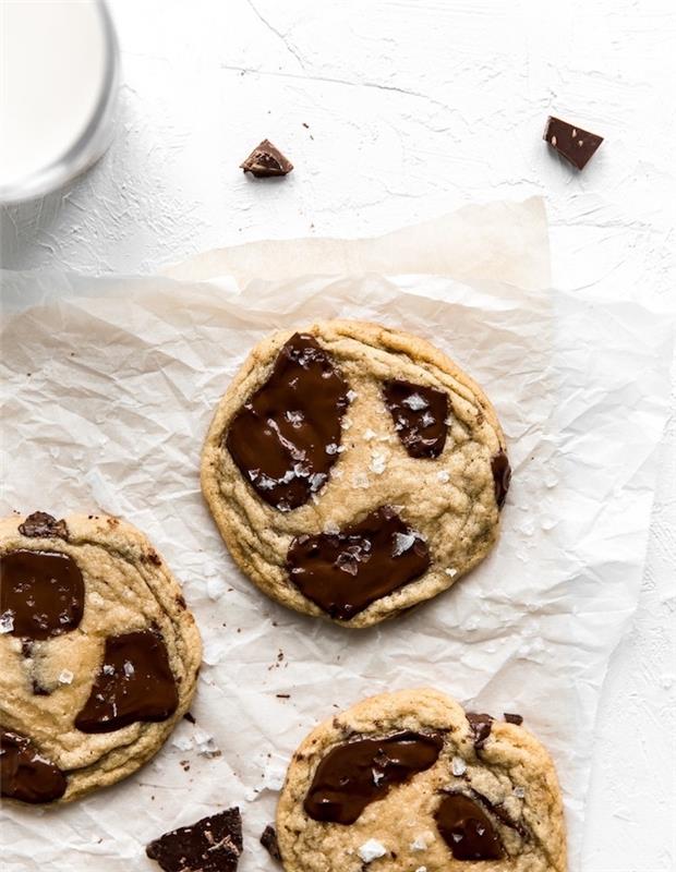 sausainiai ant balto kepimo popieriaus, su dideliais šokolado gabaliukais, kaip padaryti šokoladinius sausainius, ant viršaus druskos