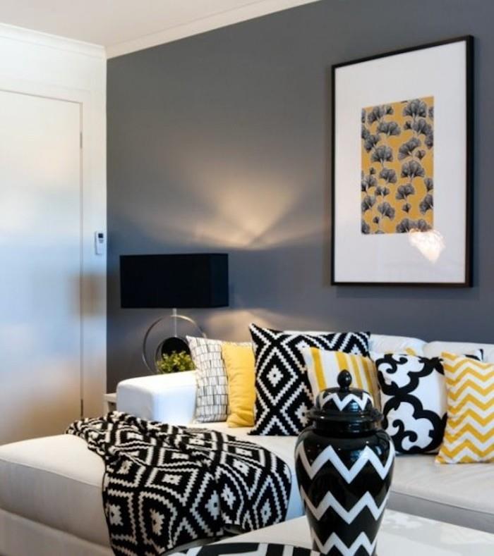 balta sofa, pilka siena, geltonos pagalvės, juoda antklodė, spalvos, derančios prie pilkos