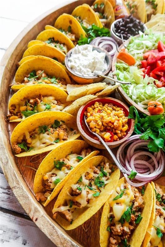 mini tacos, išdėstytos ant didelio medinio padėklo, maltos jautienos taco receptas, stikliniai dubenys, įvairūs ingredientai