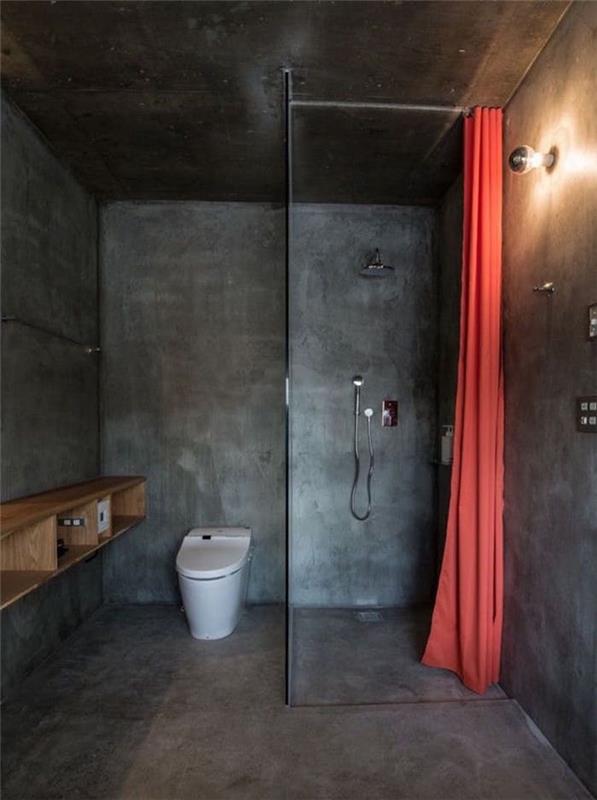 monoblok İtalyan duş ile zemin duvarları kaplayan koyu gri çimento ile küçük kapalı banyo