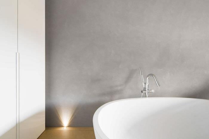bağımsız beyaz küvet ile mumlu beton banyo duvarında dekoratif örnek
