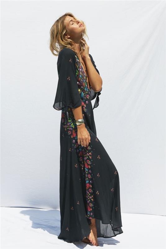 model dolge poletne obleke v črni barvi s srednje dolgimi rokavi in ​​cvetličnim okrasjem, srebrna zapestnica za poletne dodatke
