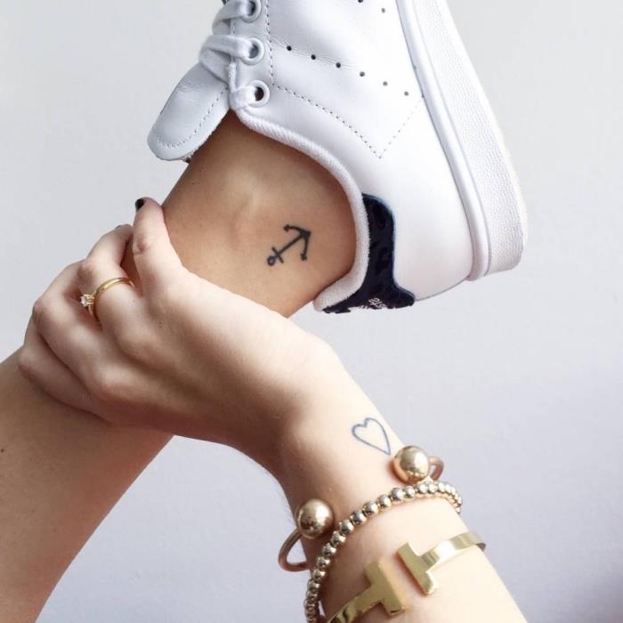 primer diskretne ženske tetovaže z majhnim sidrom na gležnju in srcem s čistimi črtami na zapestju
