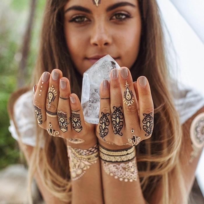 dekle, ki drži kristalno, črno -zlato tetovažo s kano, začasno tetovažo, tetovaže z prstanom