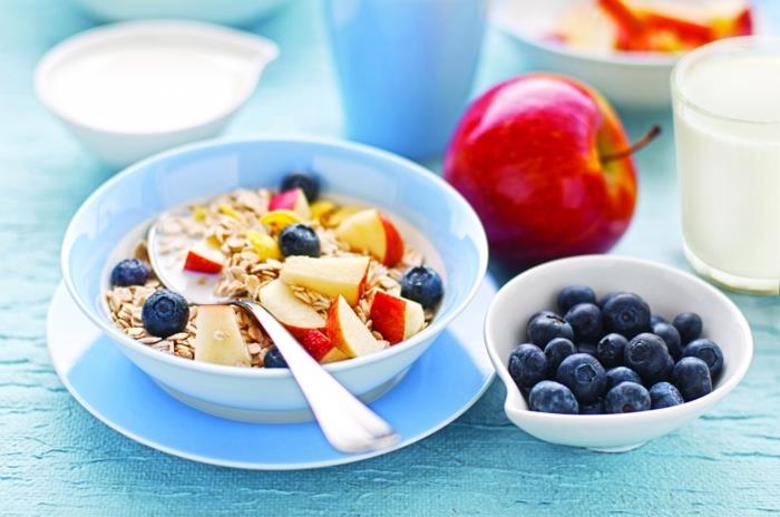 jogurt z ovsom, jabolki in robidami, v modri skledi, zdrav načrt tedenskega obroka, na modrem krožniku