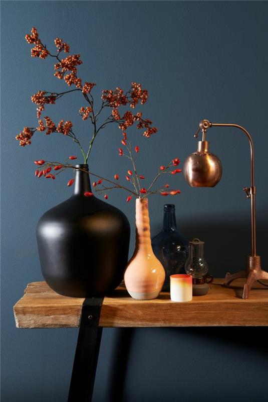 sivo modra barva na vhodu v stanovanje z grobo leseno mizo in črnimi kovinskimi nogami s črno keramično vazo
