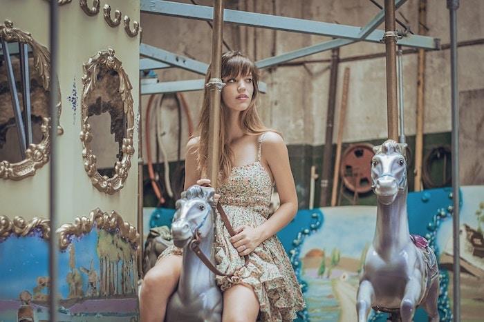 küllü sarışın, at arabası üzerinde kız, pastel pembe küçük çiçekli bej diz boyu elbise