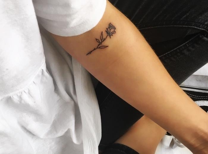 lepa rožica s črnilom na ženski roki, primer nežne tetovaže v minimalističnem duhu za ženske