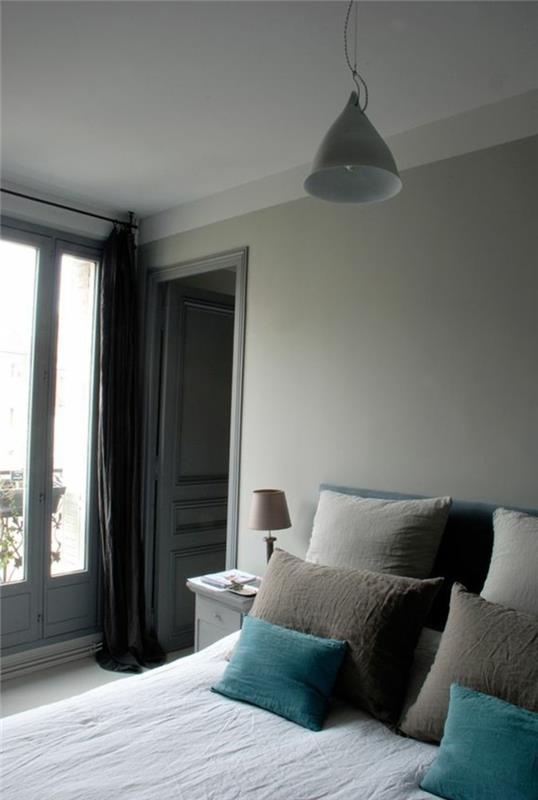 šviesiai pilkas miegamasis, lova su pagalvėmis smėlio ir turkio spalvos, minimalistinis dizainas ir apdaila