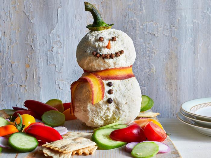 Noel aperatifiniz için basit ve blöf yapan bir başlangıç, kraker ve sebzelerle çevrili keçi peynirli ve krem ​​peynirli kardan adam