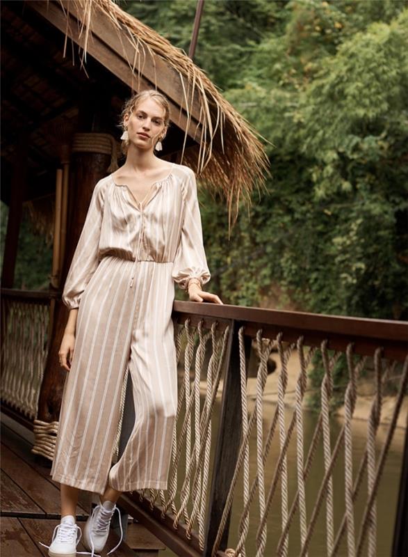 „boho chic“ dvasios tendencijos moteriška mada su prašmatniu smėlio ir baltos spalvos kombinezonu iki kulkšnies
