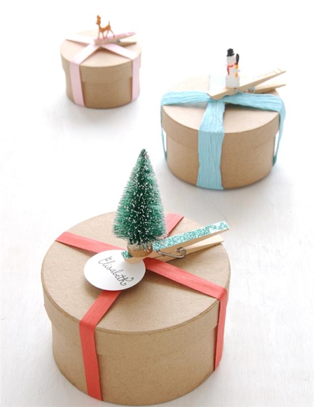 Kalėdų dovanų dėžutės pavyzdys iš cilindrinio kraftkartono, juostelės dekoravimas, drabužių segtukai, papuošti Kalėdų figūrėlėmis, Kalėdų eglutė, sniego senis, stirnaitis