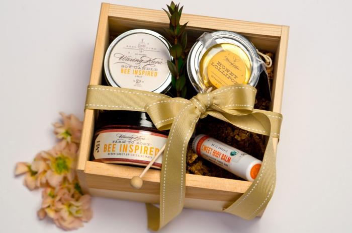 zbirka ekoloških naravnih proizvodov v leseni škatli z embalažo z zlatim trakom, kozarci naravnega ekološkega medu