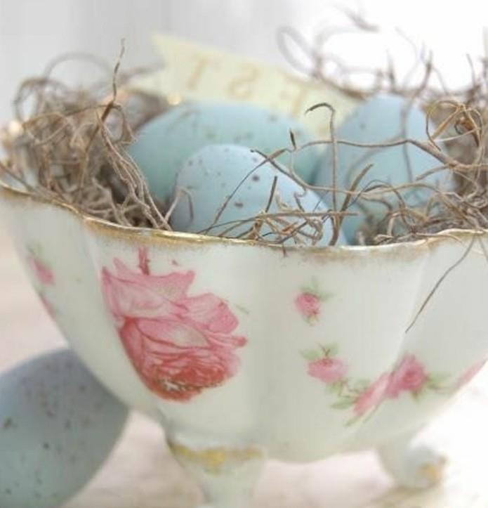 senovinis dubuo su gėlių raštais, pripildytas mėlynų kiaušinių ir sausos žolės nuostabus Velykų deko