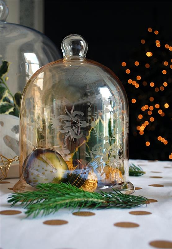 steklena škatla za sladkarije z božično kroglico, bonboni ferrero rocher, beli prt z velikimi pikami, namizna dekoracija za božič