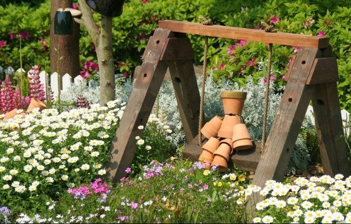 primer, da bi človek v lončkih iz terakote na gugalnici okrasil svoj vrt, ideja za dekoracijo vrta na prostem
