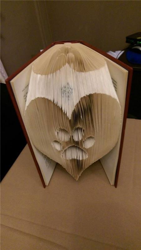 umetnost zlaganja knjig, v obliki srca s potiskom šape, narejena iz prepognjenih strani, znotraj odprte knjige, s temno rdečimi trdimi platnicami