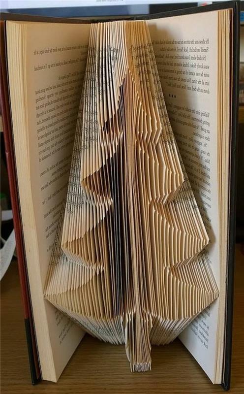 oblika božičnega drevesa iz prepognjenih strani, v odprti starinski knjigi, z rumenkastimi stranicami in rjavimi trdimi platnicami