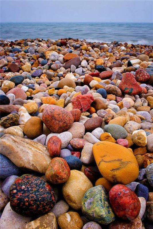 pajūris-paplūdimys-su įvairiaspalviais akmenukais