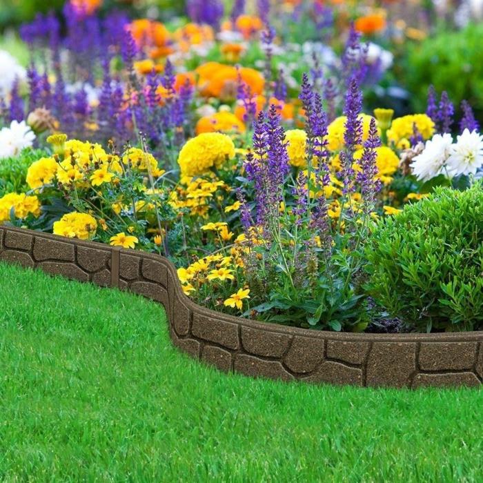 gražus gėlių sodas, skirtingos rūšys, žalia veja, surenkama siena, sodo įranga