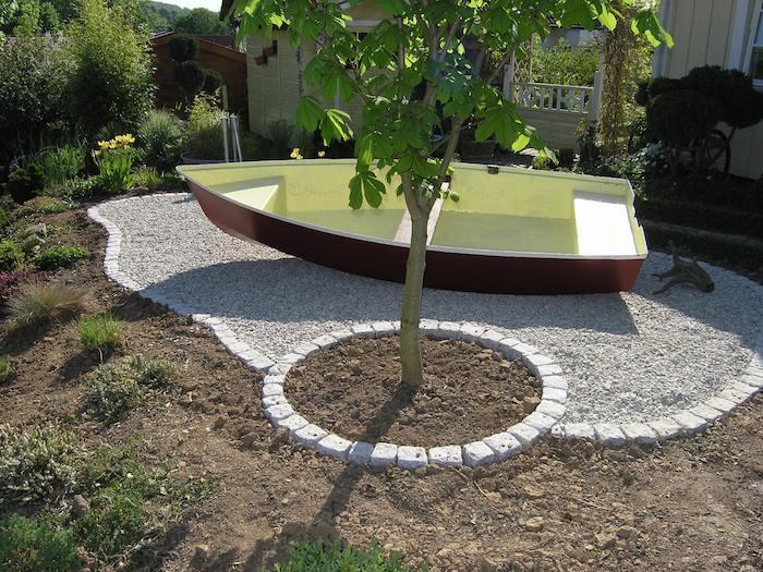ideja vrtne dekoracije, vrtnarska tehnika v geometrijskih oblikah, majhen vrt obdan s kamni z mladim drevesom