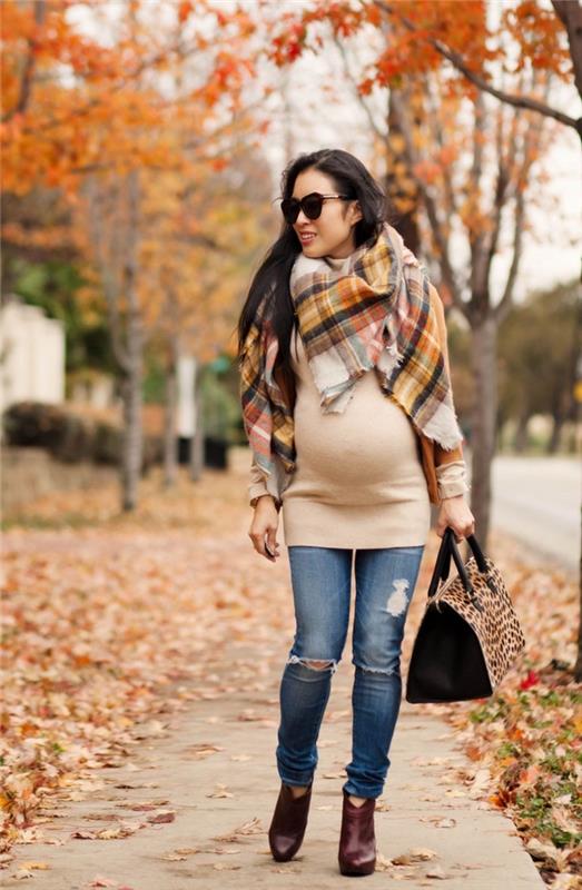 nėščiosios tunikos suknelės modelis smėlio spalvos, nėščia moteris atrodo suplyšusiuose džinsuose su megztine suknele ir skara