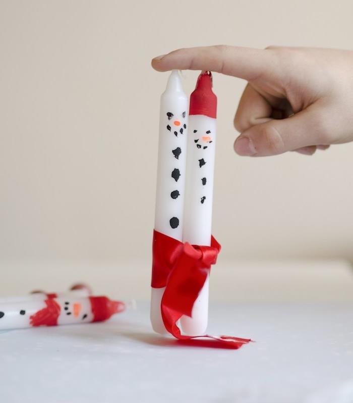 baltos žvakės, papuoštos sniego senio raštu su raudona juostele, lengvos „pasidaryk pats“ vaikų kalėdinės dekoracijos