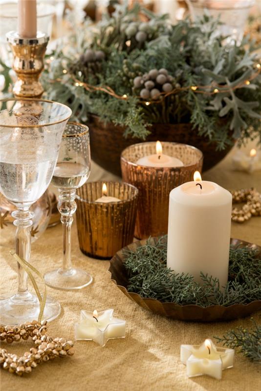 prašmatnaus stalo dekoravimo Kalėdoms su žvakėmis ir žaliomis šakomis pavyzdys, „pasidaryk pats“ gėlių kompozicija austame krepšyje
