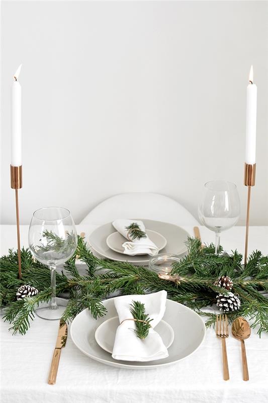 bele sveče božična miza okras narave roza zlato svečnik beli prtiček zelene veje kozarci beli borovci