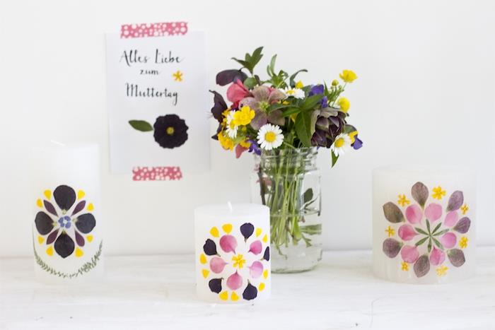 preslenmiş ve yapıştırılmış çiçek yaprakları ile süslenmiş beyaz mumlar, bahar için kolay ve hızlı zanaat etkinliği fikri