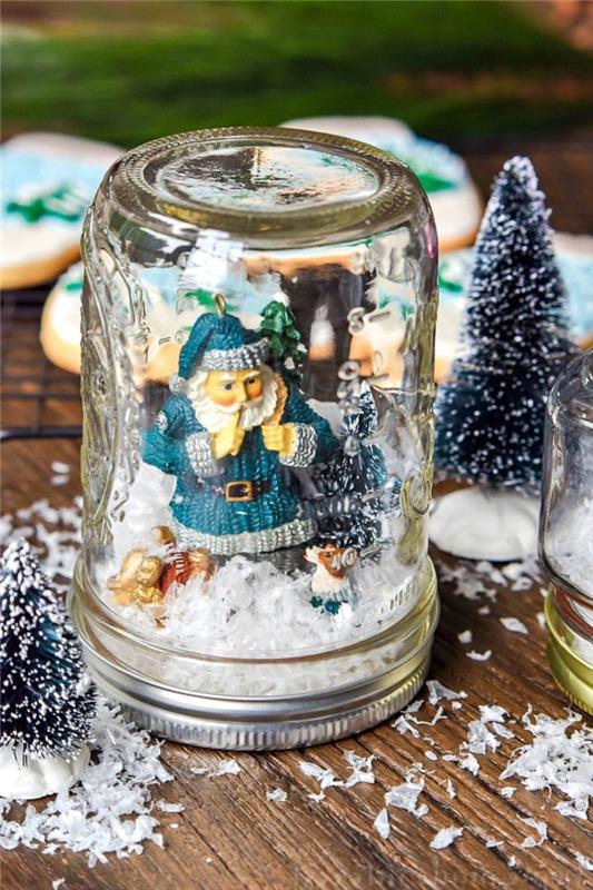 ideja za božično dekoracijo za odrasle in otroke s sneženimi steklenimi kozarci, okrašenimi z božičnimi figuricami