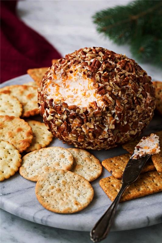 klasičen recept za pikantno sirno kroglico kot božični aperitiv, ki ga spremljajo slani krekerji