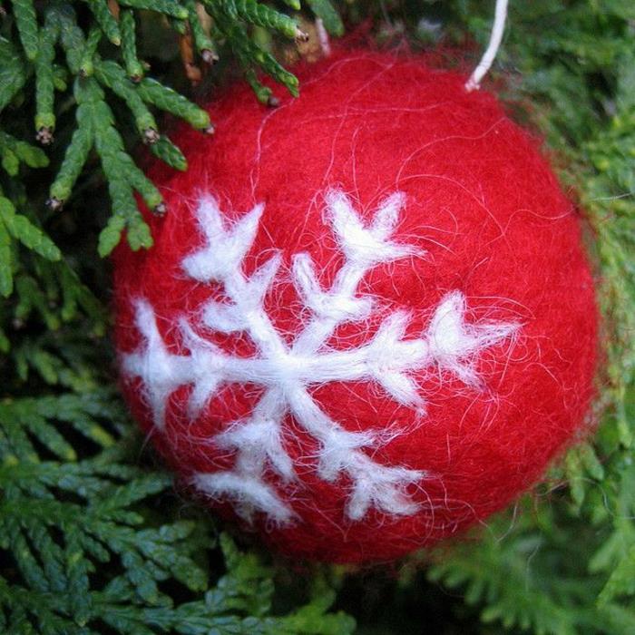 Kalėdų kamuolys pakabinti ant eglutės, papuoštos snaigėmis