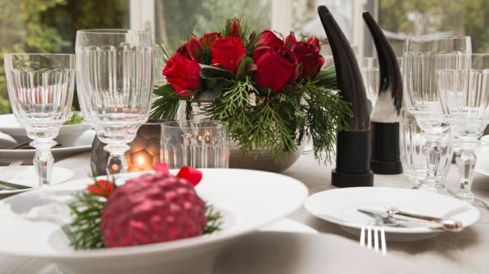 okrogla vaza z rdečimi vrtnicami, okraski za božično mizo, okrasna krogla v krožniku