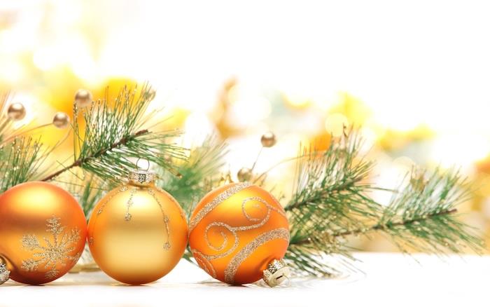 Kalėdiniai tapetai aukso spindesio geltonuose rutuliuose, raštų ir sniego kolbos papuošimas pilkais blizgučiais, pušies šakos