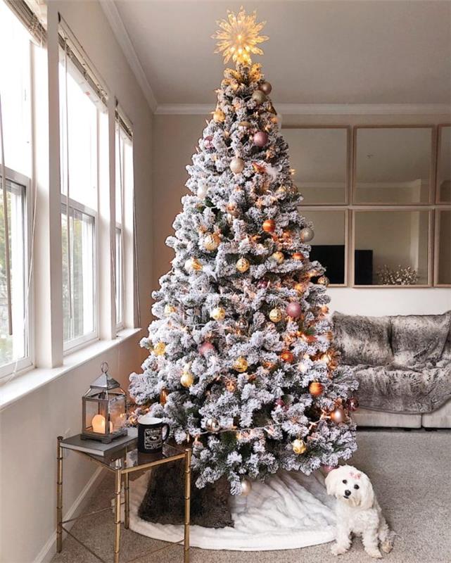 Božične kroglice rožnato zlato srebrno zlato in svetleča zvezda ideja umetno božično drevo s snežnim učinkom na polarni beli preprogi