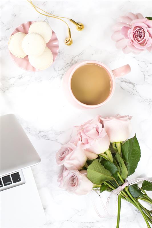 pisarniško pohištvo, dekoracija delovnega prostora v beli in pastelno roza barvi, skodelica kave in majhen krožnik v pastelno roza barvi