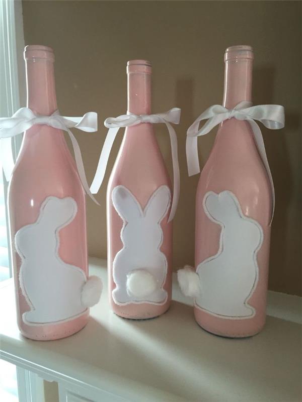 beyaz pamuk kuyruklu tavşan motifi ve beyaz kurdele ile pembe boya ile boyanmış geri dönüştürülmüş şarap şişeleri
