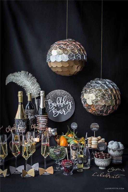 Novoletna sladkarija s pijačami in majhnimi novoletnimi aperitivi z deko srebrnimi zrcalnimi kroglicami, srebrno pero