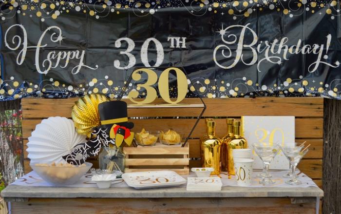 suorganizuokite nepamirštamą vakarėlį 30 -mečio tema, vakarėlio dekoras baltos ir juodos spalvos su aukso ir medžio akcentais