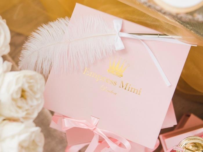 kakšno presenečenje za žensko, ideja za darilo za 14. februar, škatla za perilo v pastelno roza barvi s trakom in belim perjem