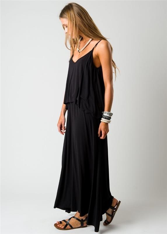 hipių prašmatnaus stiliaus juodos ilgos suknelės modelis kartu su juodomis plokščiomis basutėmis ir apyrankės bei karolių aksesuarais