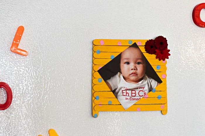 mažos mamos dienos dovanos idėja su darželio vaikais, naminis nuotraukų rėmelis geltonai dažytomis medinėmis lazdelėmis su taškeliais