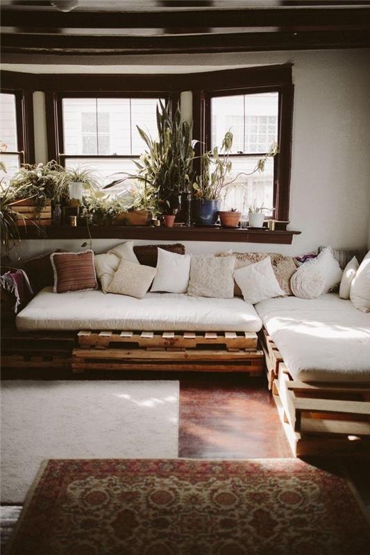Birçok minder sayesinde bohem şık bir dinlenme köşesine dönüşen paletlerle yapılan geniş köşe kanepe