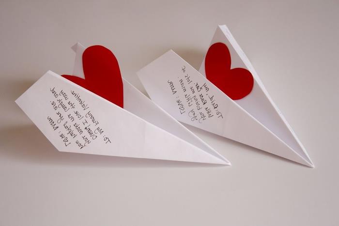 mažos originalios meilės žinutės popierinėse plokštumose, papuoštose mažomis popierinėmis širdelėmis