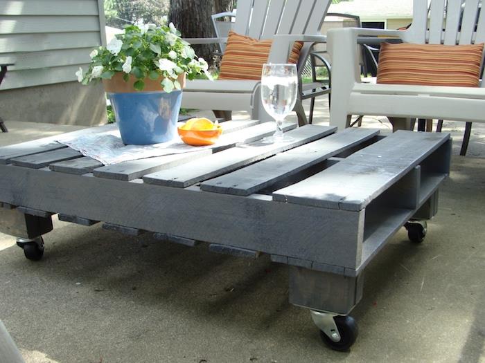 gri boyalı palet ve monte edilmiş tekerlekler, bahçe sandalyeleri ile yapımı kolay bir palet sehpa örneği