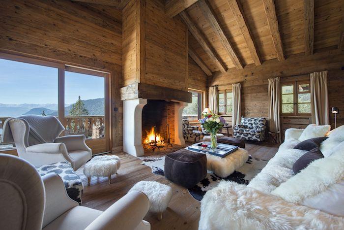 Lesena dekoracija dnevne sobe, hladna notranjost brunarice o udobju s kaminom, prižganim ognjem, velikim oknom s čudovitim razgledom